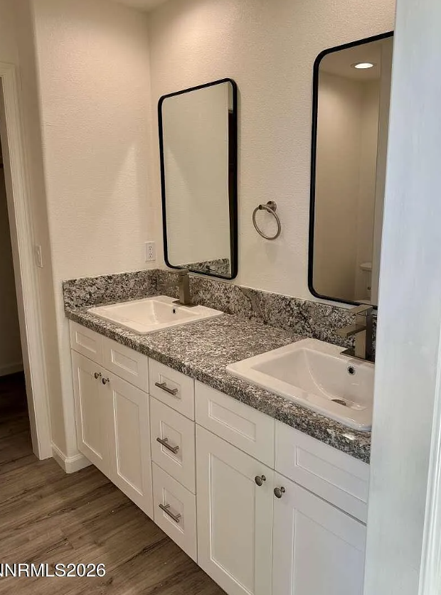 Bathroom finish reference with double white vanity, granite countertop, black-framed mirrors, and LVP flooring